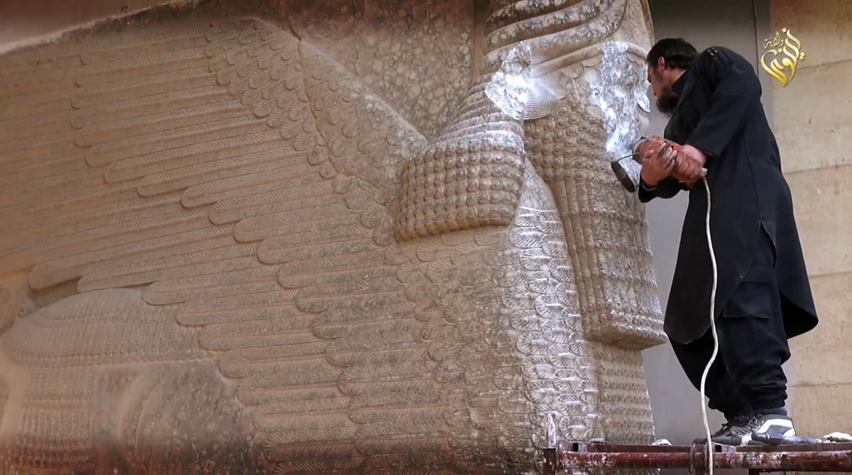 an image grab taken off a video reportedly released by media office of the nineveh branch of the islamic state is group on february 25 2015 allegedly shows an is militant destroying the statue of lamassu an assyrian diety with a jackhammer in the northern iraqi governorate of nineveh photo afp