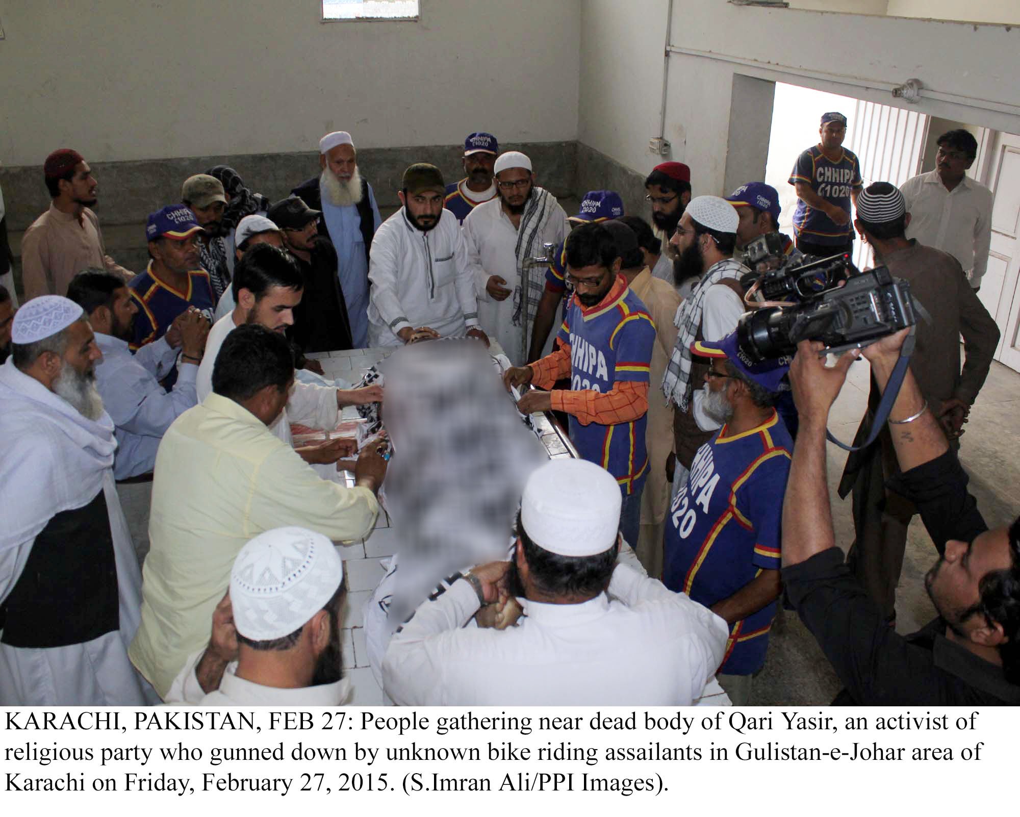 people gather near the body of qari yasir who was gunned down on friday photo ppi