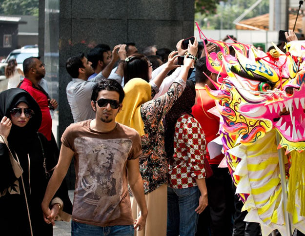 a tourist couple walks on a street in kuala lumpur photo afp