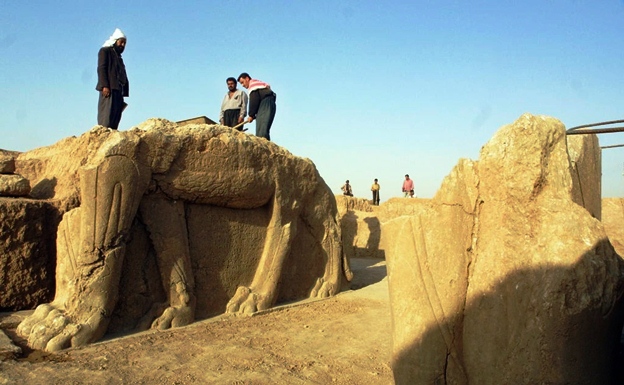 a file picture taken on july 17 2001 shows iraqi workers cleaning a statue of winged bull at an archeological site in nimrud photo afp