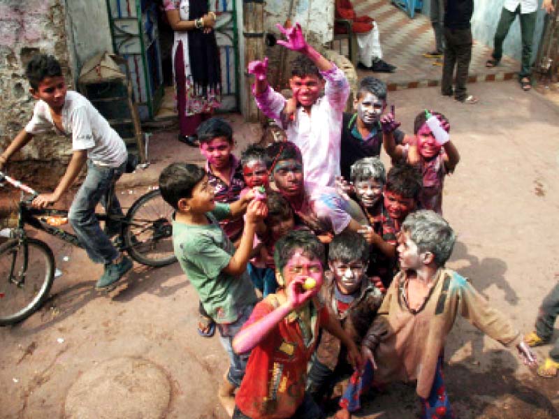 young boys spray each other with colours at narainpura mandir photo online