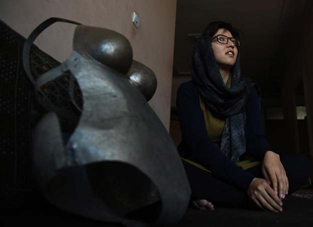 afghan artist kubra khademi 27 sits alongside a suit of armour she made as a protest against sexual harrassment during an interview with afp in kabul on march 8 2015 photo afp