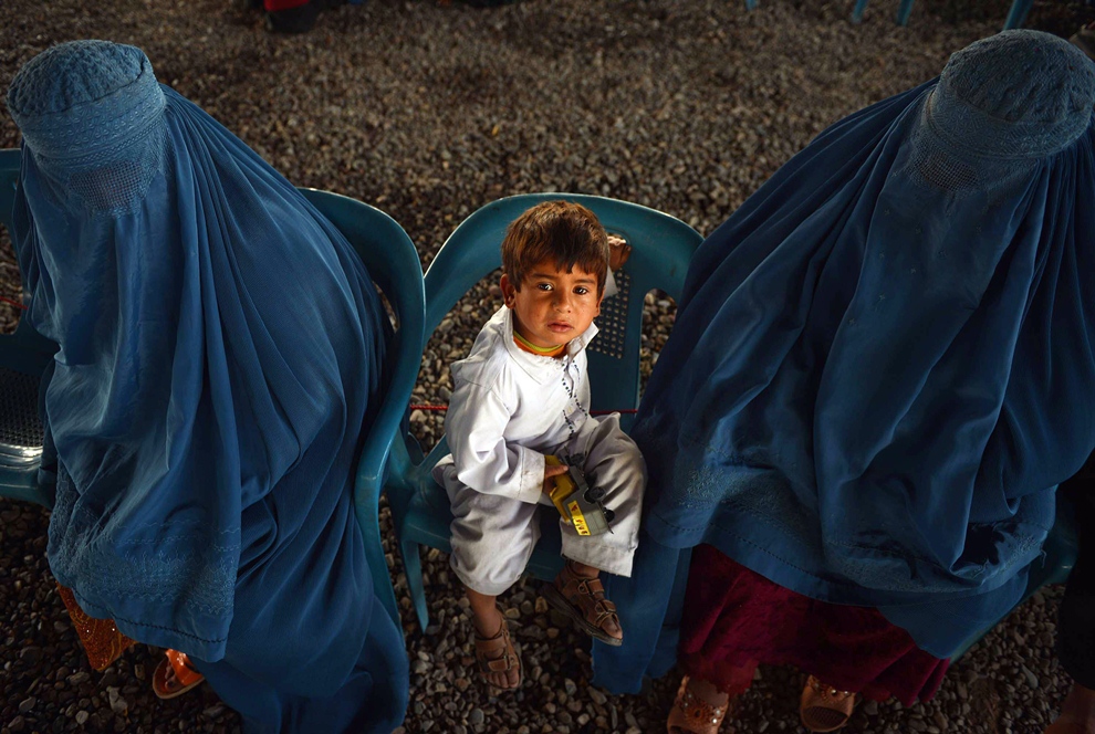 an afghan refugee family sitting at the united nations high commissioner for refugees unhcr registration centre on the outskirts of peshawar before their departure to their home country photo afp