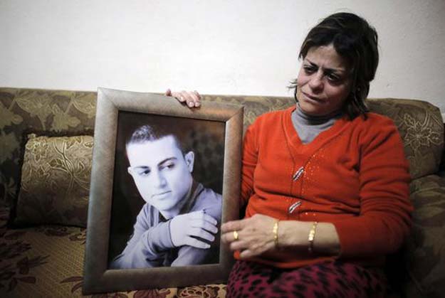 the mother of muhammad musallam an israeli arab held by islamic state in syria as an alleged spy weeps as she holds his photograph in her east jerusalem home february 12 2015 photo reuters