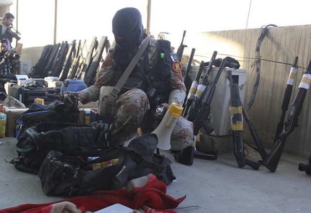 a rangers soldier displays weapons recovered during a raid on mqm headquarters in karachi on march 11 2015 photo reuters a rangers soldier displays weapons recovered during a raid on mqm headquarters in karachi on march 11 2015 photo reuters