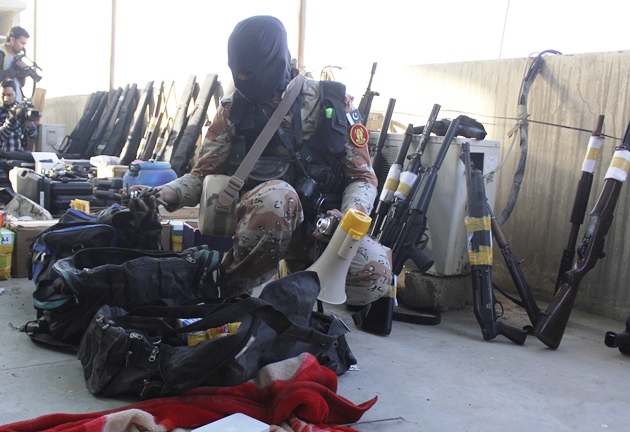 a paramilitary soldier displays weapons recovered during a raid on the muttahida qaumi movement mqm political party 039 s headquarters in karachi photo reuters