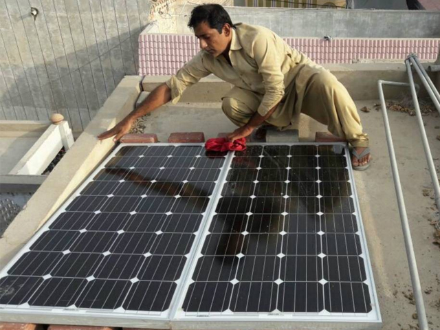 a man wipes the dust off solar panels he recently installed on the roof of his home in larkana in pakistan s sindh province june 28 2017 photo reuters