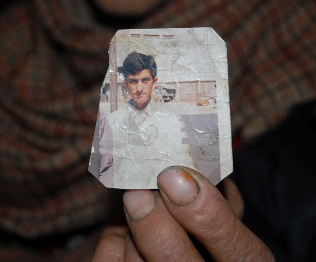 this photograph taken on march 12 2015 shows one of the azad kashmir parents of convicted killer shafqat hussain holding a photograph of their son in muzaffarabad the capital of pakistani administered kashmir photo afp