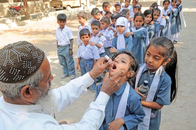 a health worker administers the polio vaccine to schoolchildren in karachi photo file