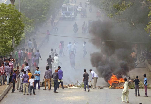 a mob lights bonfires on the road after attacks on churches in lahore right a woman mourns the death of her relative photos afp reuters