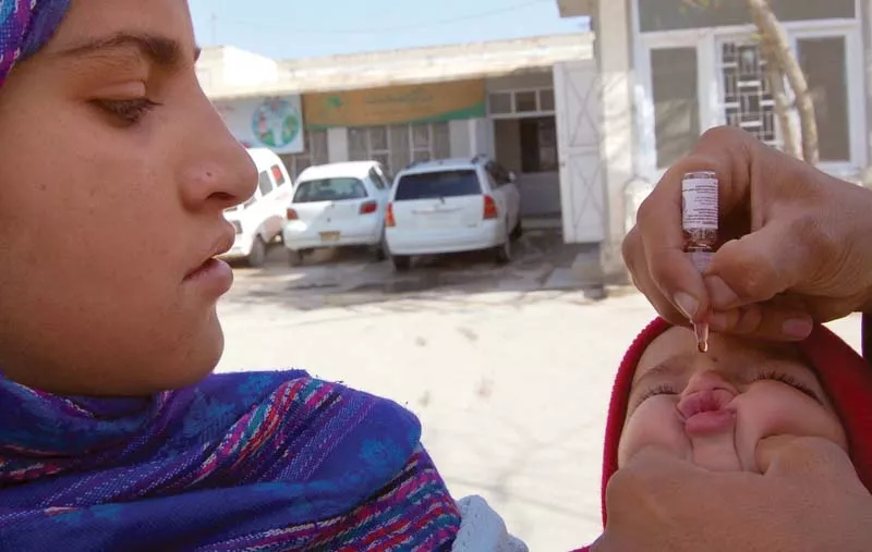 health worker administers polio drops to a child in chaman town that borders with afghanistan photo inp health worker administers polio drops to a child in chaman town that borders with afghanistan photo inp