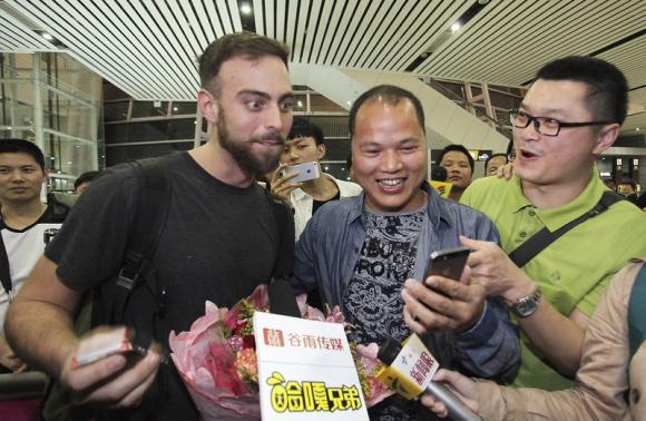 buzzfeed writer matt stopera l of the us reacts as he looks at a mobile phone held by 039 brother orange 039 c of china at an airport in jieyang guangdong province march 17 2015 photo reuters