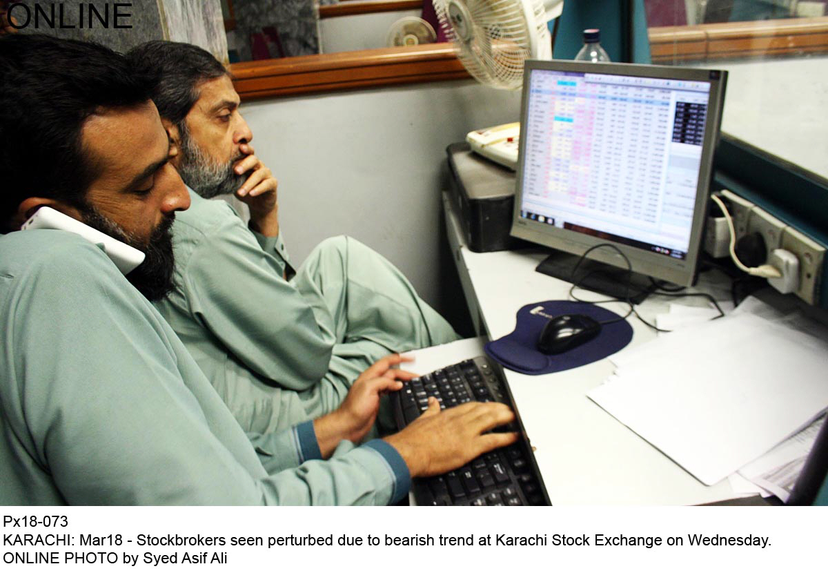 two stock brokers watch on as the kse 100 index goes through a slump photo online