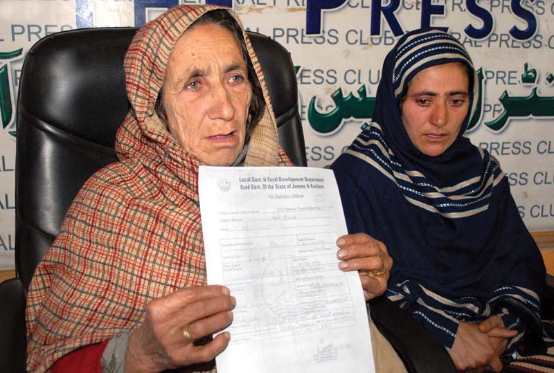 the mother of shafqat hussain showing his birth certificate during at press conference at the central press club in muzaffarabad photo inp