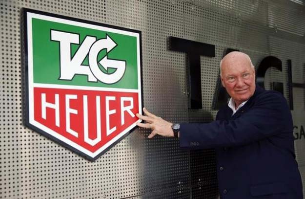 jean claude biver head of french luxury goods group lvmh 039 s watch business and interim ceo of the group 039 s biggest watch brand tag heuer poses in front of the company 039 s logo before a news conference in the western swiss town la chaux de fonds december 16 2014 photo reuters