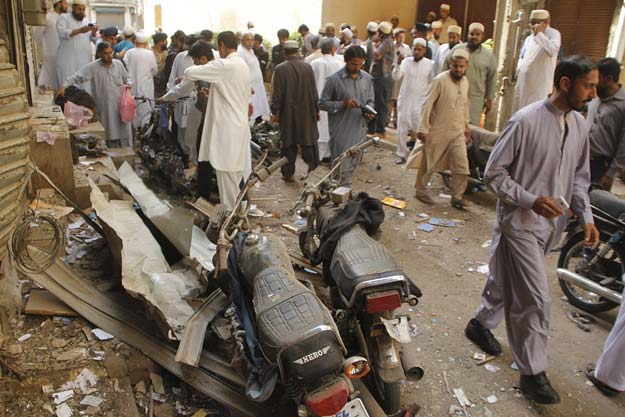 people inspect the blast site in aram bagh area of karachi photo afp