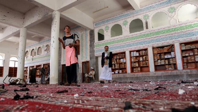 yemeni armed men inspect the damage following a bomb explosion at the badr mosque in southern sanaa on march 20 2015 photo afp