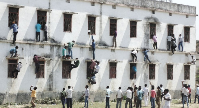 family members and friends climb walls to make answer chits available to those appearing for their class 10 exams at a centre in vaishali bihar photo courtesy dipankar family members and friends climb walls to make answer chits available to those appearing for their class 10 exams at a centre in vaishali bihar photo courtesy dipankar