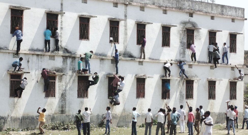 family members and friends climb walls to make answer chits available to those appearing for their class 10 exams at a centre in vaishali bihar photo courtesy dipankar