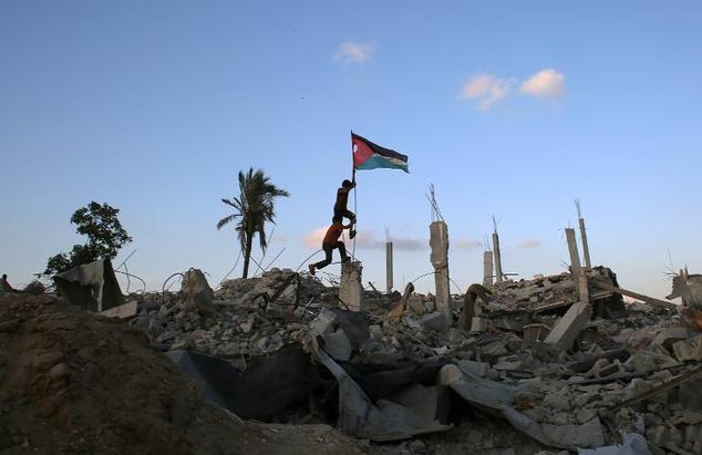 children in khan yunis 039 khuzaa neighbourhood in the southern gaza strip place a palestinian flag on october 1 2014 in the rubble of a building destroyed during the israeli army 039 s summer offensive on the gaza strip photo afp