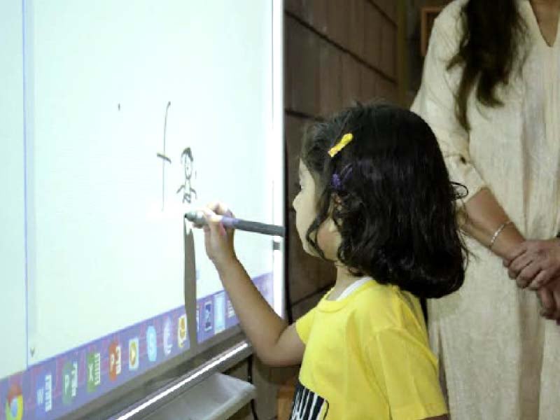 a little girl draws a picture on a smart board at civitas school civitas is an elementary school project for students from nursery till class six photo courtesy civitas