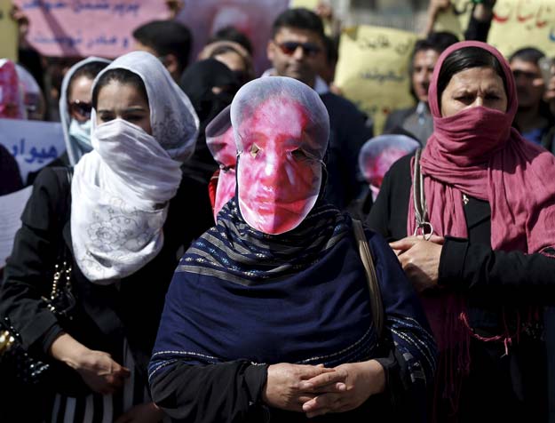 afghans from the hmbastagi party solidarity party of afghanistan wear masks during a protest to condemn the killing of 27 year old woman farkhunda who was beaten with sticks and set on fire by a crowd of men in central kabul in broad daylight on thursday in kabul march 23 2015 photo reuters