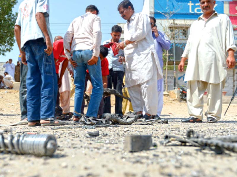 investigators collecting evidence are looking at the pieces that were left scattered as a result of the bomb attack on a police mobile van on friday morning on national highway photo afp