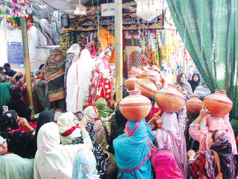 women devotees carrying pitchers of rose water to wash the shrine photo abid nawaz express