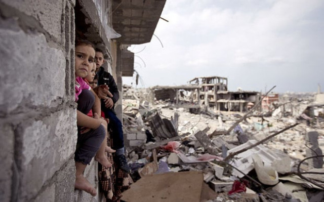 palestinian children sit on the window of a partially destroyed building in al tufah east of gaza city photo afp