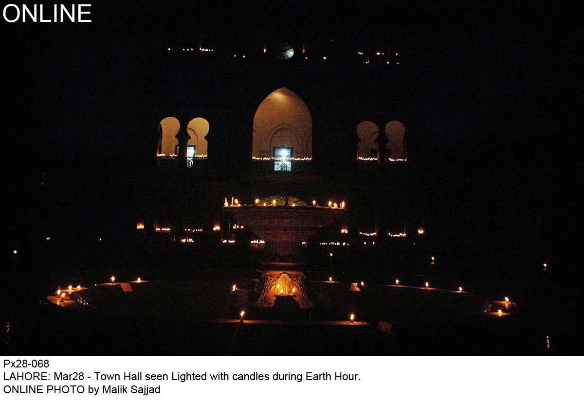 town hall seen lit with candles during earth hour photo online