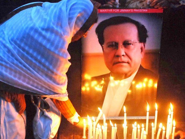 a file photo of woman lights a candle at a remembrance ceremony held for former governor punjab salmaan taseer in lahore photo nni file