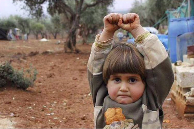 four year old syrian boy adi hudea poses arms raised in surrender after mistaking a camera for a gun photo osman sa rl