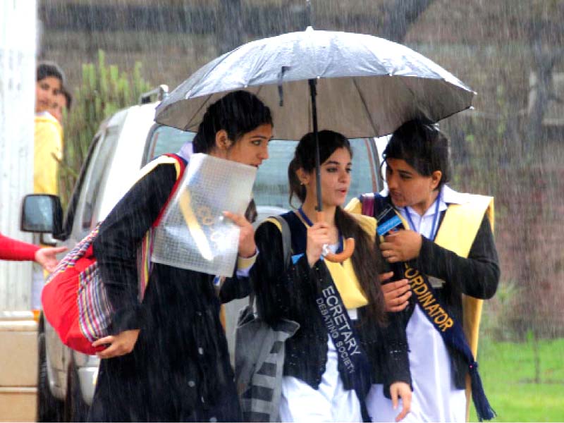 three girls share an umbrella on their way to school traffic moves slowly due to mud on the main road near metro bus project near faizabad rain worsened traffic jam on an already congested street in rawalpindi clockwise from top left photo nni online inp