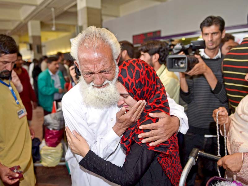 a man hugs his daughter at the islamabad airport on her return from yemen another batch of pakistani expatriates stranded in the war torn country returned on friday photo afp