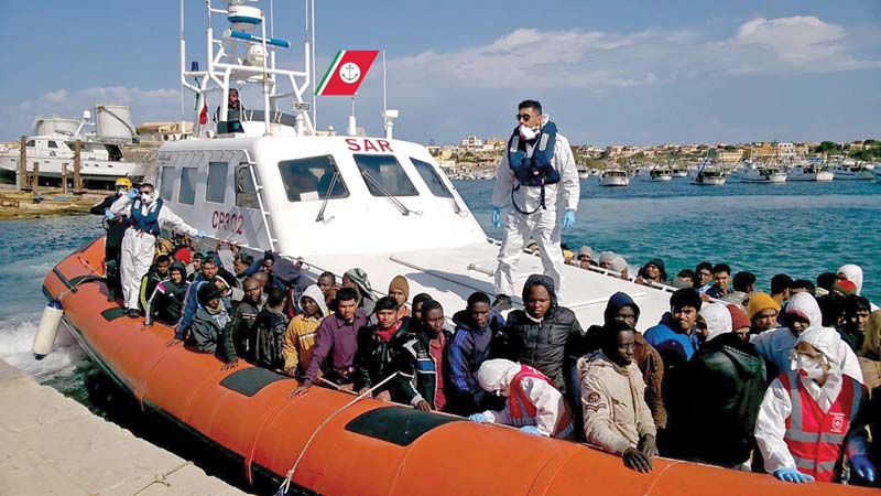 in this videograb released by the italian coast guards migrants arrive in the port of lampedusa on a boat of the coast guards following a rescue operation off the coast of sicily photo afp