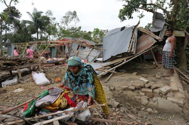 a bangladeshi victim gathers her belongings near her home which was destroyed during storms 200kms from dhaka photo afp a bangladeshi victim gathers her belongings near her home which was destroyed during storms 200kms from dhaka photo afp