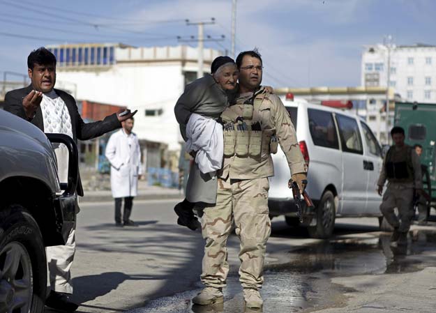 a member of the afghan security force holds a woman while rescuing her from the site of an attack in mazar i sharif april 9 2015 photo reuters