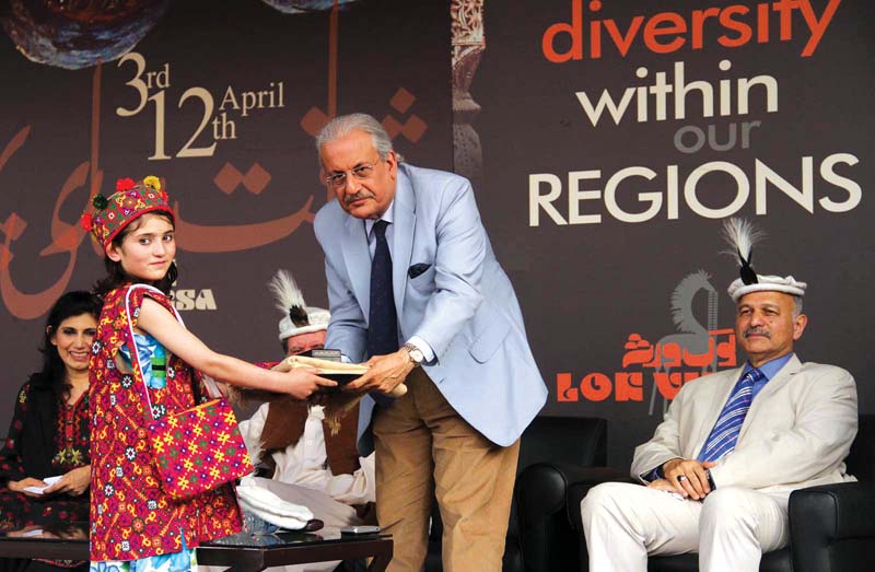 senate chairman raza rabbani receives a gift from a girl in recognition of his services for restoring the constitution on the constitution day r cultural artists perform at the ceremony in lok virsa l photos muhammad javaid express