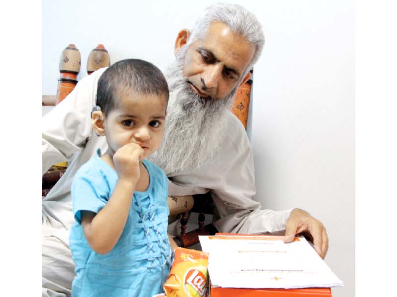 a child with a cochlear implant in her ear eats her snack duhs treated 12 other such children last month they had hearing disability but now thanks to the implants they can hear and are ready for speech therapy photo aysha saleem express