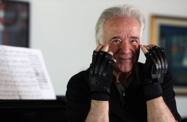 brazilian conductor and pianist joao carlos martins 80 who after many years lost the ability to play due to health complications from focal dystonia poses for a picture with bionic gloves at his house in sao paulo brazil october 28 2020 photo reuters