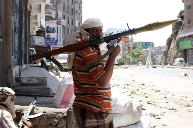 yemeni tribal gunmen of the popular resistance committees loyal to president abedrabbo mansour hadi monitor a street with their weapons during clashes with huthi rebels on april 16 2015 in the city of taez photo afp