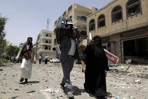 yemenis carrry their belongings after their family house was hit during a raid by saudi led coalition warplanes on a missile depot on fajj attan hill in the rebel held part of the yemeni capital in southern sanaa on april 20 2015 photo afp