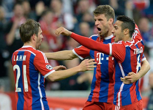 bayern munich 039 s midfielder thomas mueller c celebrates scoring with his team mates defender philipp lahm l and spanish midfielder thiago alcantara r during the uefa champions league second leg quarter final football match bayern munich v fc porto in munich southern germany on april 21 2015 photo afp