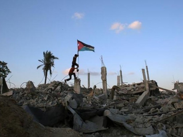 palestinian children raise their flag on the debris of a building destroyed by israeli forces photo afp