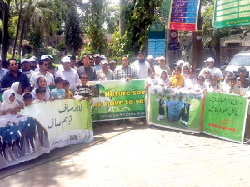 participants of an awareness walk carrying banners to highlight environmental issues at the lahore zoo on wednesday photo inp
