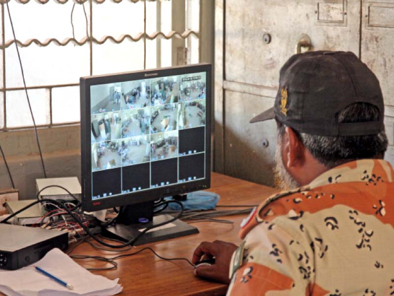 an officer of the paramilitary force looks at the security camera footage at a polling station as the votes were being cast on thursday photo athar khan express