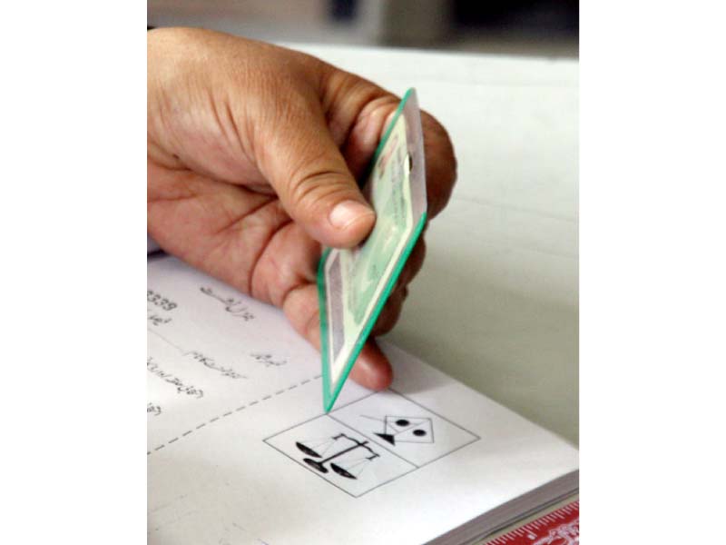 a voter stamps the ballot paper at a polling station in cantonment board clifton photo athar khan express