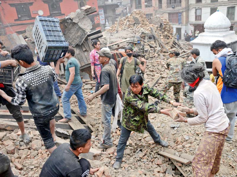 people clear rubble in kathmandu s durbar square that was severely damaged by the earthquake on saturday photo afp