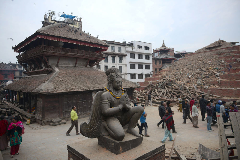 nepalese residents walk beside buildings severely damaged by an earthquake on kathmandu on april 26 2015 rescuers in nepal searched frantically for survivors of a quake that killed more than 2 000 digging through rubble in the devastated capital kathmandu and airlifting victims of an avalanche at everest base camp photo afp