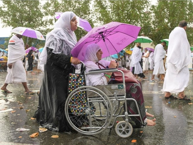 muslim pilgrim walk in the rain near mount arafat as the climax of the hajj pilgrimage approaches on august 10 2019 photo getty